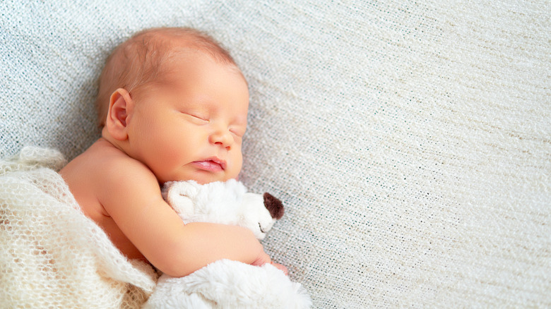 Baby cuddling a teddy bear