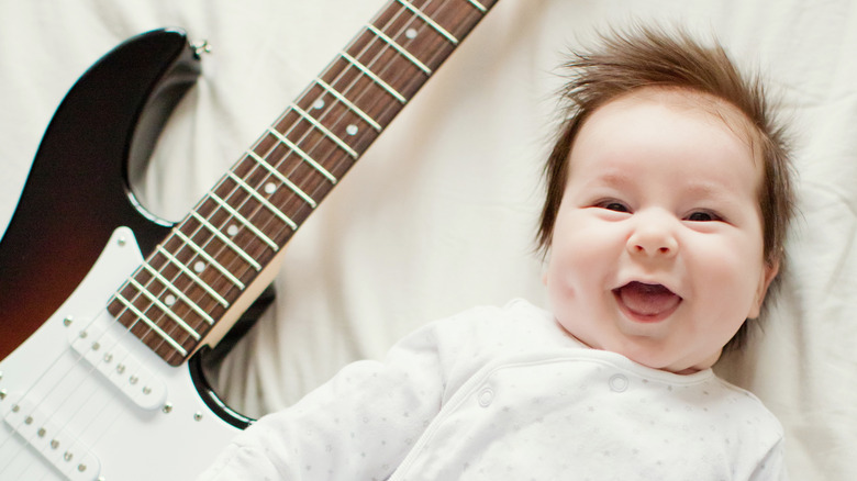 Baby smiling near guitar