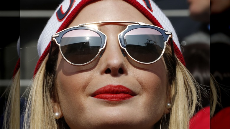Ivanka Trump in a bright bold lip and sunglasses staring out at the Olympics