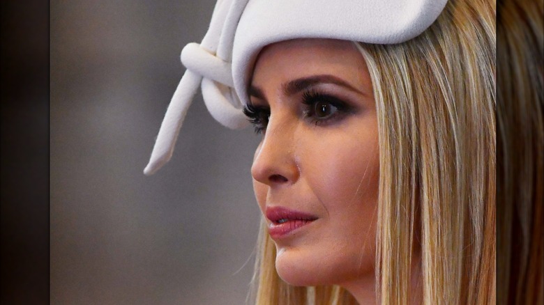 Ivanka Trump in an assymetrical white headpiece and wide-eyed stare