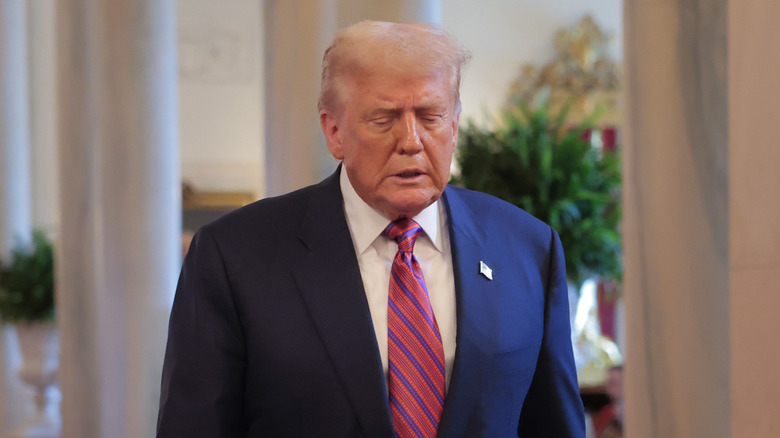 Donald Trump looks down while walking