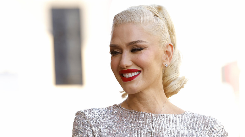 Gwen Stefani ponytail, red lip, wearing silver