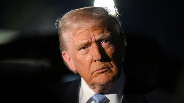 Donald Trump looking grumpy in a black suit