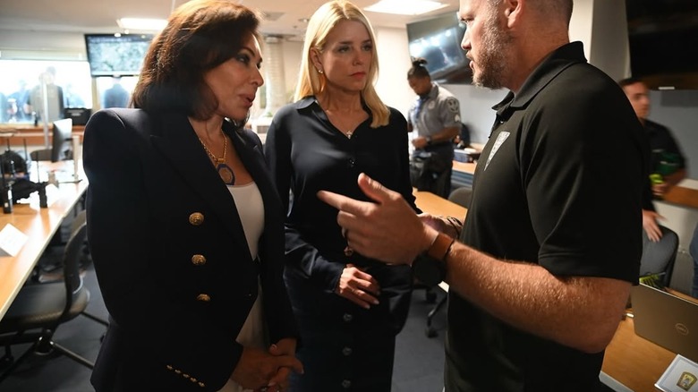 Jeanine Pirro and Pam Bondi talk to a man.