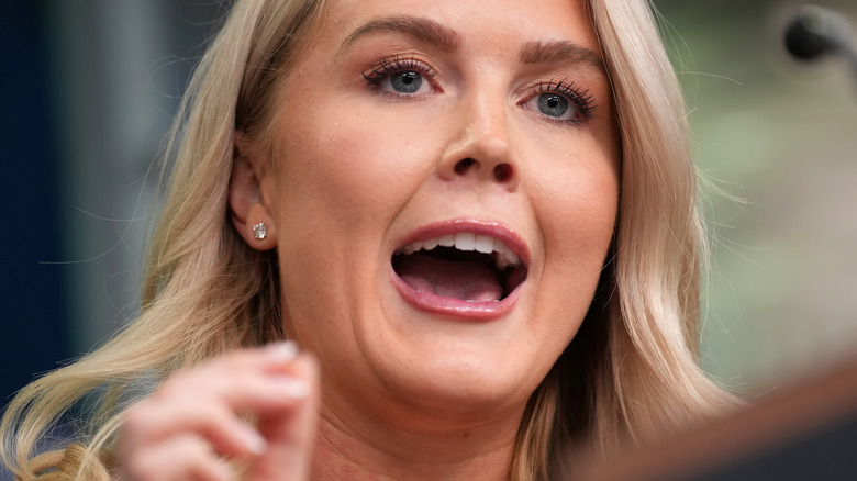 Karoline Leavitt giving a press conference at the White House briefing room