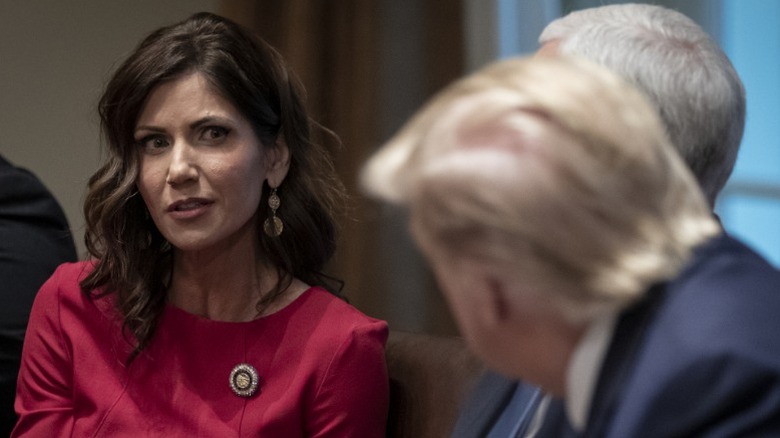 Kristi Noem speaks to Donald Trump during a meeting in the White House in Washington, DC (2019)