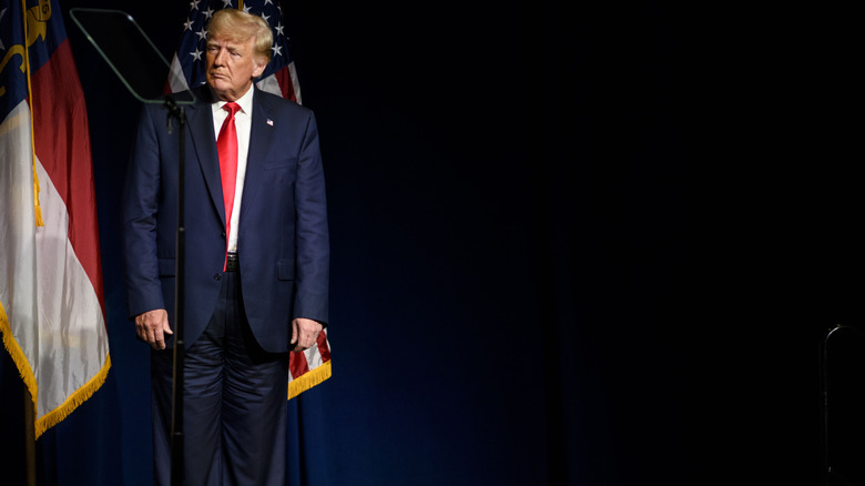 Donald Trump wears wrinkled pants and stands behind a teleprompter at the 2021 NCGOP state convention.