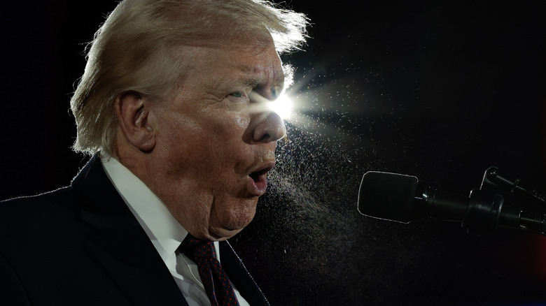 Spit flies from Donald Trump's mouth as he speaks with a light behind him at the National Republican Congressional Committee's annual fundraising dinner.