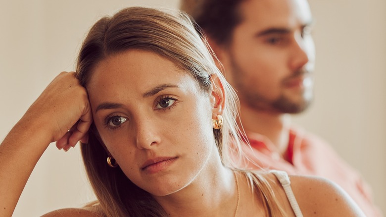 Unhappy couple, woman resting hand on temple