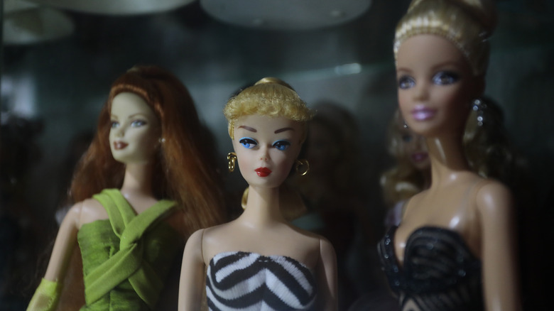 Three vintage Barbies under dim lighting