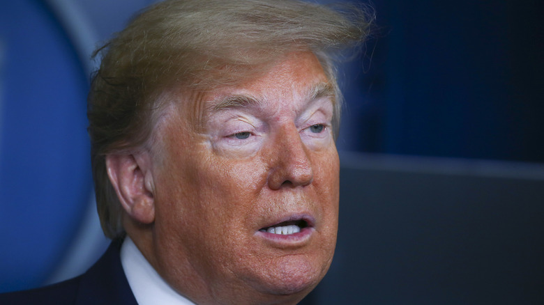 At a press briefing, Donald Trump has white circles of bare skin around his eyes.