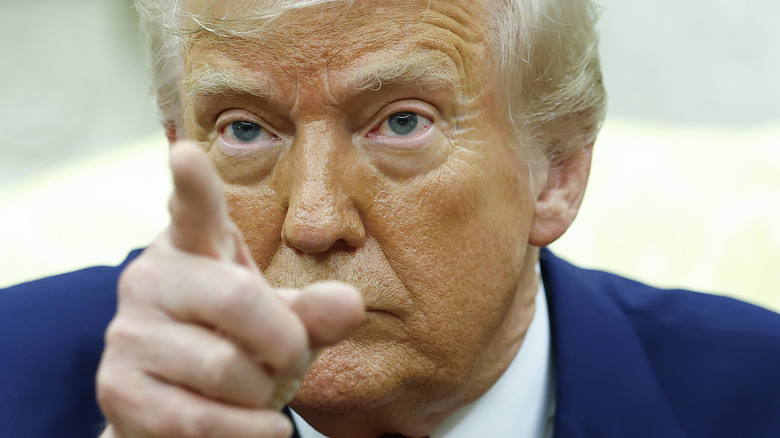 The creases beside Donald Trump's eyes are white in a close-up of him pointing.