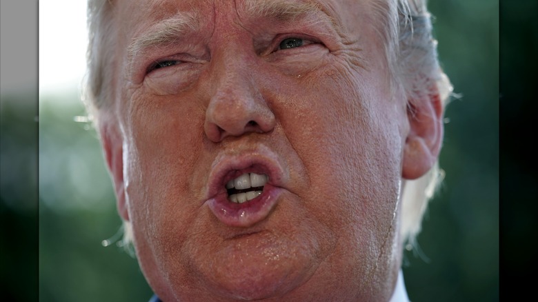In a close-up photo, sweat drips down Donald Trump's face as he squints and forms an "O" with his mouth.