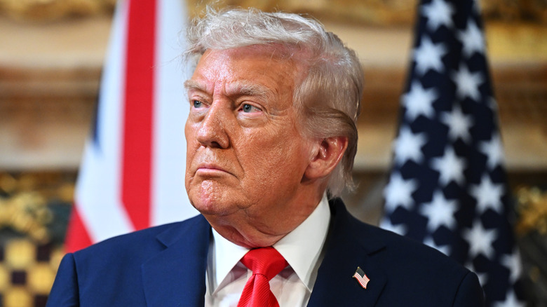 Donald Trump looks up and to the side with patches of pink skin on his chin and forehead.