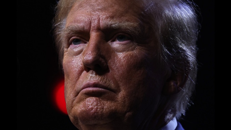 Donald Trump's face is sweaty and the skin around his eyes is pink in a close-up photo.