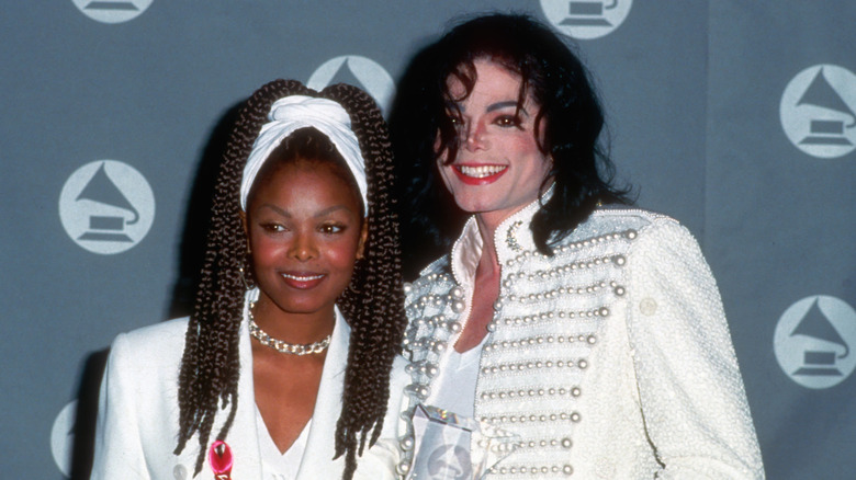 Janet Jackson and Michael Jackson smiling in all-white outfits.