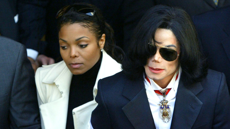 Janet Jackson in a white coat walking next to Michael Jackson in a dark coat.