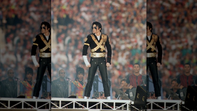 Michael Jackson standing onstage in front of a massive audience.