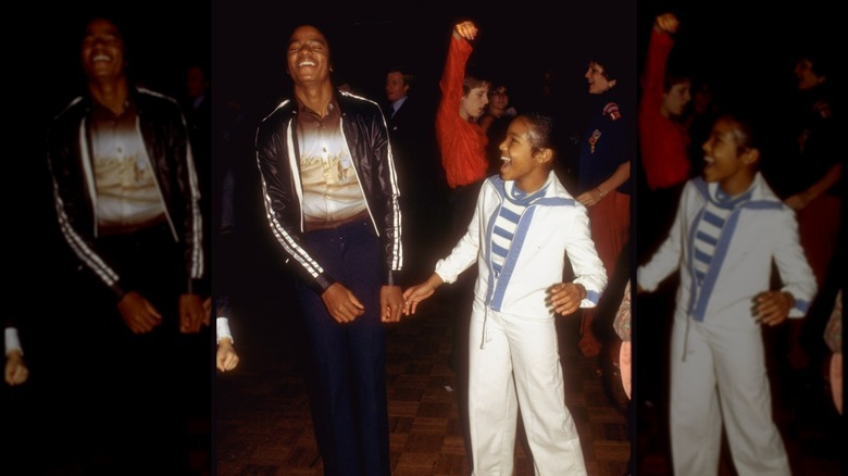 Young Michael Jackson laughing and smiling while dancing next to Janet Jackson
