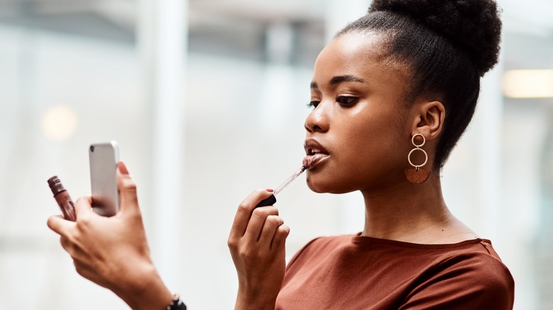 Woman applying lipstick 