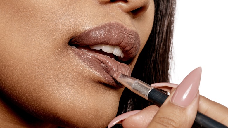 Close up of woman applying lipstick