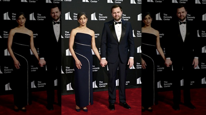 Usha and JD Vance holding hands and staring straight ahead