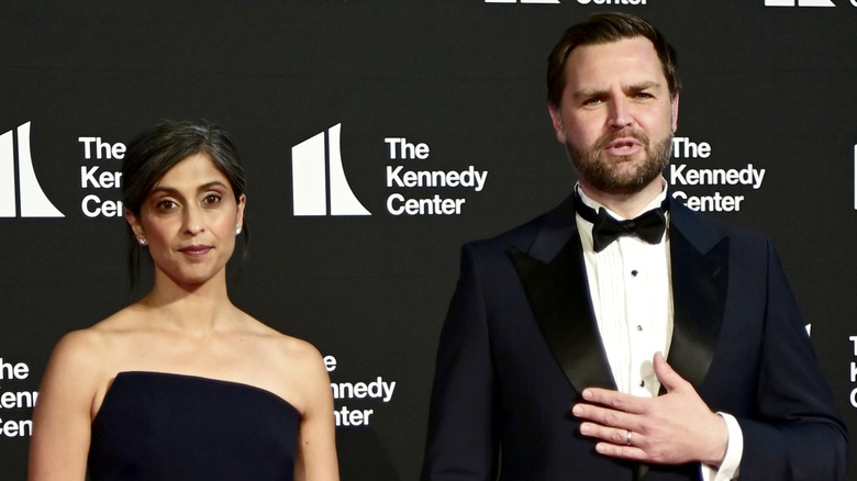 Usha Vance posing in a black dress next to JD Vance who's wearing a suit and bowtie.