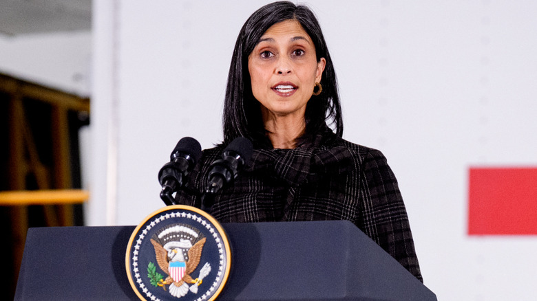 Usha Vance speaking at a podium in a black check jacket