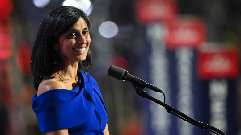 Usha Vance smiles while standing at a microphone
