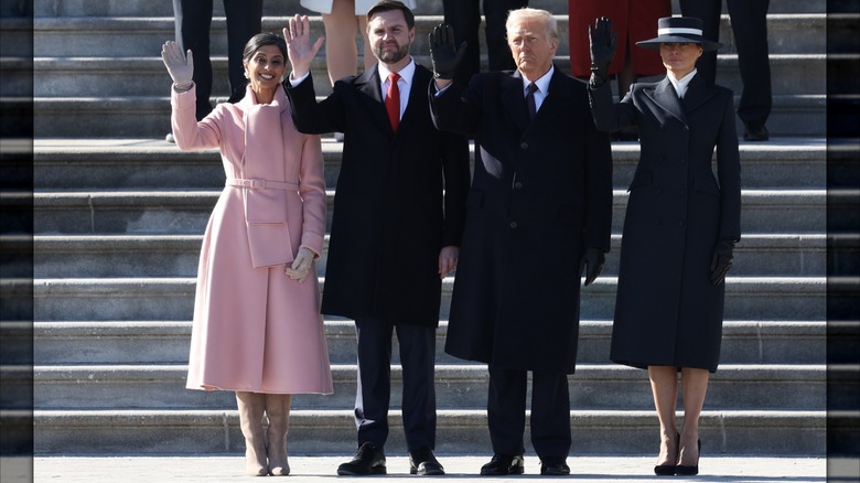 Usha Vance (L) wearing a pink coat and waving next to JD Vance, Donald Trump, and Melania Trump (L-R) at a departure ceremony for former President Joe Biden.