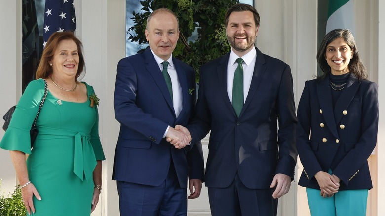 Usha Vance (R) smiling in a dark blue navy blazer and green khakis next to JD Vance, Micheál Martin, and Mary Martin (R-L)