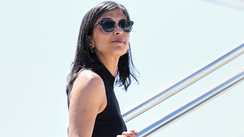 Usha Vance wearing sunglasses and a black dress as she boards a plane