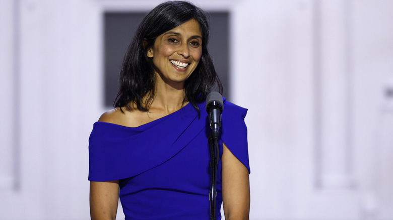 Usha Vance smiling as she delivers a speech in a blue dress