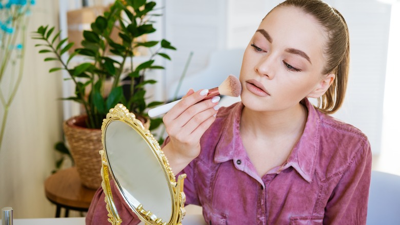 Woman applying foundation with fingers