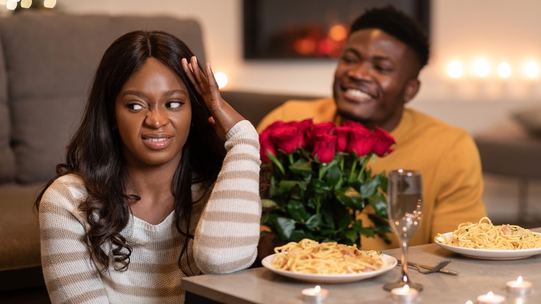 Woman and man on a date at home with woman unhappy