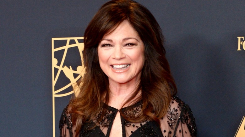 Valerie Bertinelli smiling in a black lace dress at an event