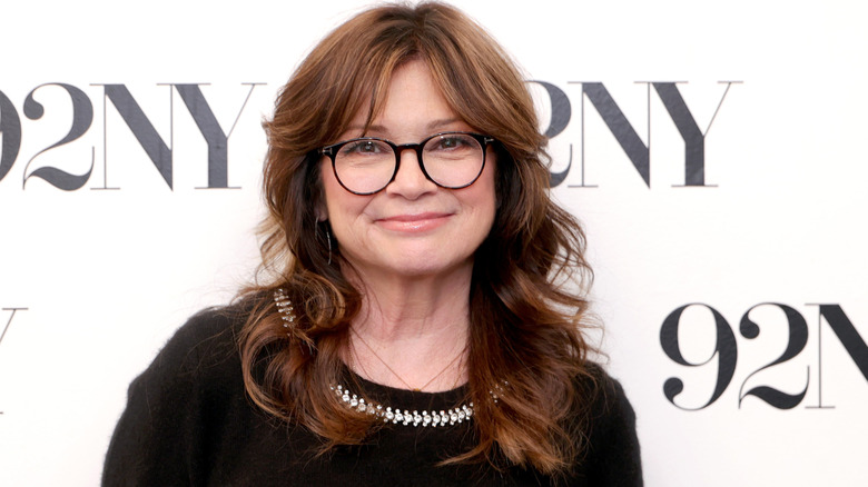 Valerie Bertinelli smiling while posing at an event in a black top and glasses