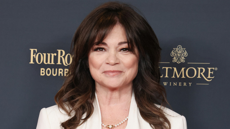 Valerie Bertinelli in front of black backdrop with gold text
