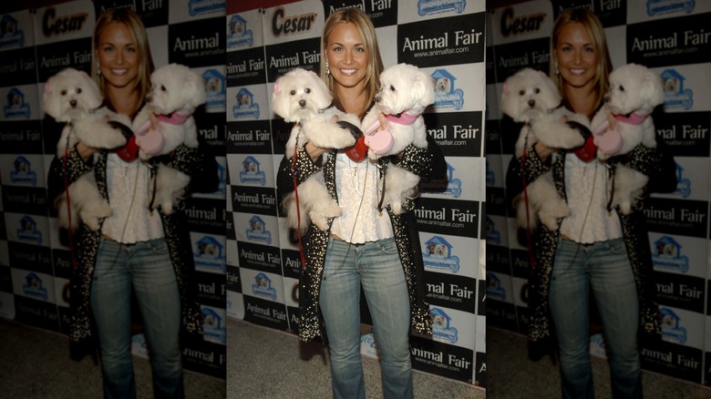 Vanessa Trump posing on step-and-repeat with two dogs at animal fair