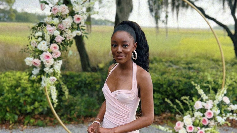 Venita Aspen posing outside in a pink dress