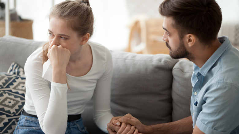 man holding crying woman's hand