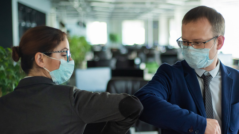 Two businesspeople giving a COVID handshake