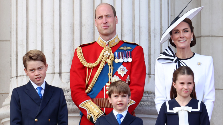 Prince William and Kate Middleton standing with their kids on the Buckingham Palace balcony.