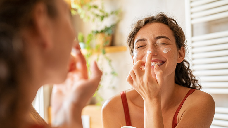 A woman applying moisturizer 