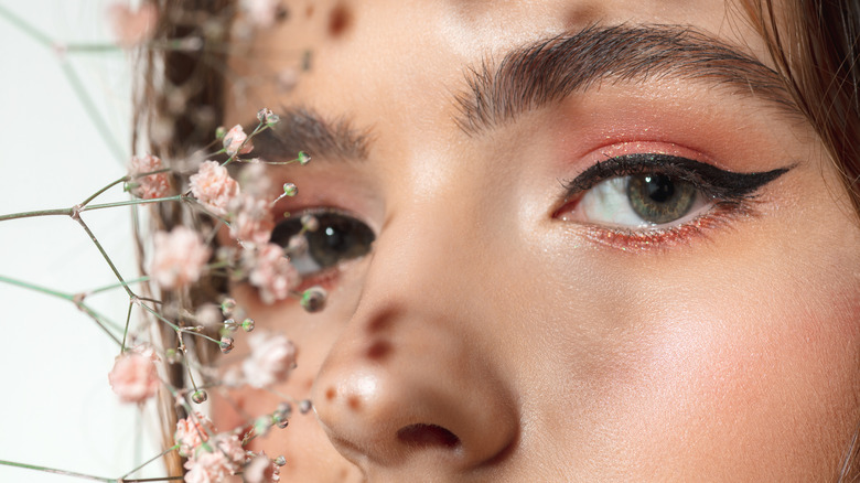 Young girl with small flowers in front of her face