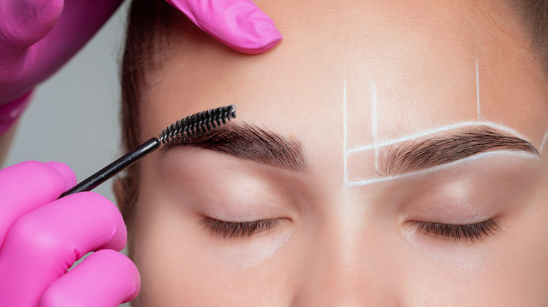 Makeup artist lining eyebrows