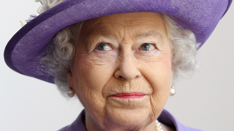 Queen Elizabeth posing in purple outfit 
