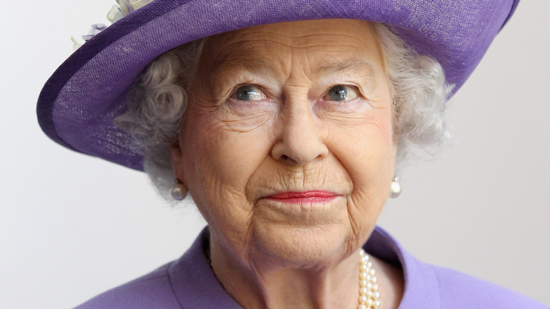 Queen Elizabeth posing in purple outfit