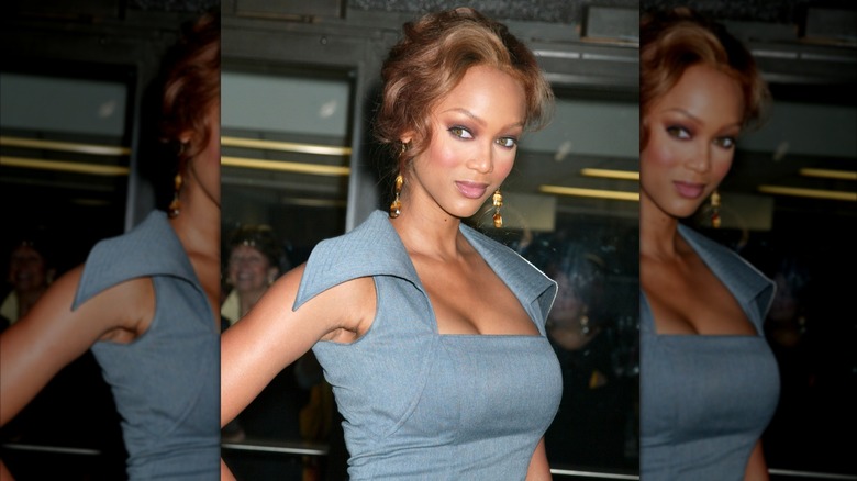 Tyra Banks smiling for the camera circa 2005 in a blue dress