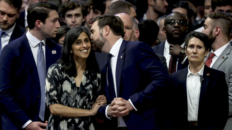 Usha Vance smiling while JD talks in her ear.